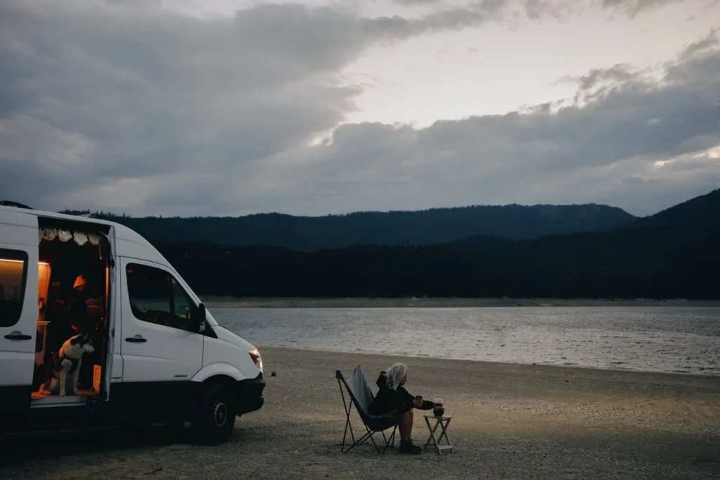 Furgoneta camperizada aparcada en la naturaleza adaptada como oficina móvil para nómadas.